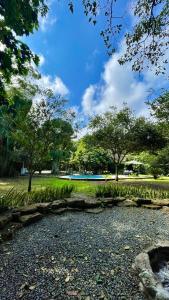 a park with trees and grass and a road at El Campito Lodge in Ayampe