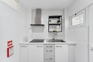 a white kitchen with a sink and a window at GuestReady - Lovely home with river view in Bandeira