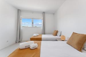 a white room with two beds and a window at GuestReady - Lovely home with river view in Bandeira