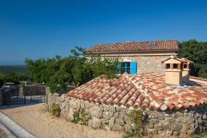 a building with a tile roof and a stone wall at Villa Marevic in Vrh