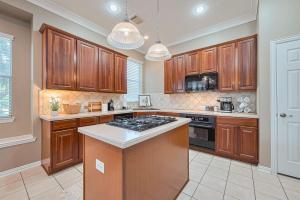 a kitchen with wooden cabinets and a stove top oven at Peaceful Exec Home w Office Near Everything in Conroe
