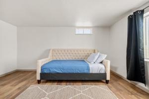 a bedroom with a bed with blue sheets and a window at Rancho Alegre Country Retreat in Pueblo