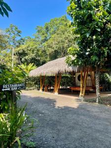 a pavilion with a bench and a grass roof at El Campito Lodge in Ayampe