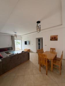 a living room with a table and a couch at Imiouadar residence tafoult appartement in Imi Ouaddar
