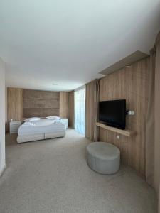 a bedroom with a bed and a flat screen tv at Riviera Blue Hotel in Sunny Beach