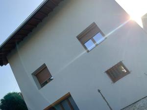 a white house with three windows on the side of it at Bonneville hébergement in Bonneville +7 photos