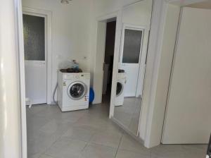 a laundry room with a washing machine and a washer at Residence Mary in Velipojë