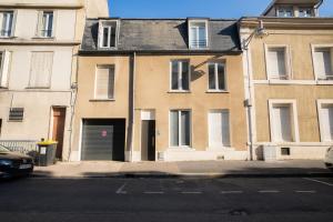 an apartment building with a garage on a street at Le Chativesle - Centre - Erlon in Reims