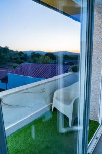 a glass window with a table on a balcony at Pousadas CAMINO de FINISTERRE in Mazaricos