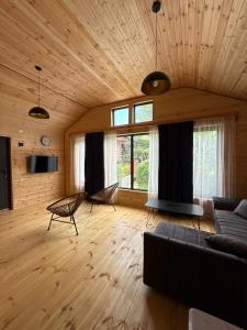 ein Wohnzimmer mit einem Sofa, einem TV und Fenstern in der Unterkunft Orion Palace in Batumi