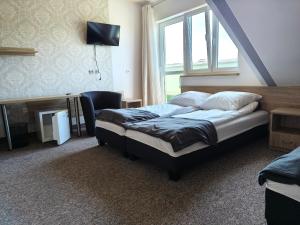 a hotel room with a bed and a window at Joanna in Krasnobród
