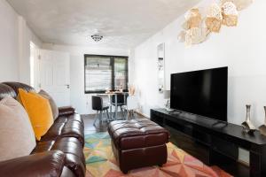 サウサンプトンにあるLeaside House by Grandeur Propertyのソファと薄型テレビのあるリビングルーム