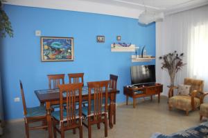 ein Wohnzimmer mit einem Esstisch und einer blauen Wand in der Unterkunft Golem Apartments in Golem
