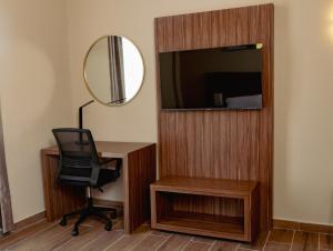 a room with a desk and a chair and a mirror at Hotel Embajadores Matamoros in Matamoros
