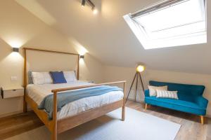 a bedroom with a bed and a blue couch at Luz Marina in Ribadeo