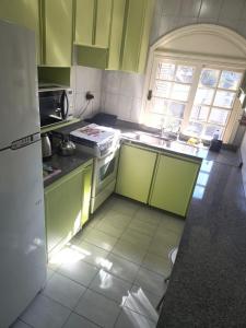a small kitchen with green cabinets and a sink at Apartamento na Avenida Borges a 100 m da Rua Coberta in Gramado