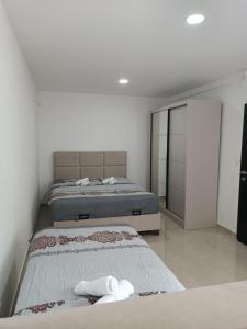 Dos camas en una habitación con paredes blancas. en Vila Eden, en Bar