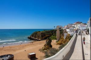 a view of a beach with people and the ocean at Bayview Old Town Beach Apartment in Albufeira