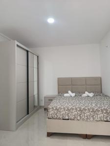 a white bedroom with a bed and a dresser at Vila Eden in Bar +16 photos