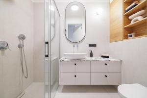 un bagno bianco con lavandino e specchio di Sea Nature Kolibki a Gdynia