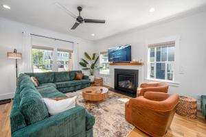 a living room with a green couch and a fireplace at The Terra Haus - 4BR Modern Boho Retreat in Durham