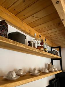 a wooden shelf with dishes and bottles on it at Konstantina 2 in Ayía Varvára