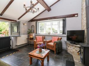 a living room with two chairs and a tv at Pear Tree Cottage in Mark
