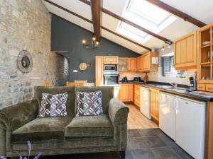 a living room with a couch in a kitchen at Pear Tree Cottage in Mark