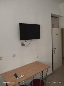Un televisor de pantalla plana colgado en una pared en Hostel Lux, en Bitola