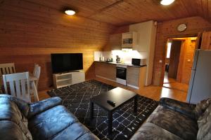 a living room with a couch and a kitchen at Mökkitunnelmaa kaupungista in Seinäjoki