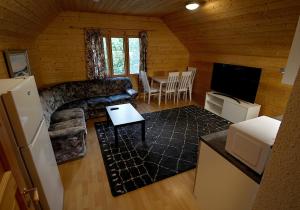 a living room with a couch and a tv and a table at Mökkitunnelmaa kaupungista in Seinäjoki +4 photos