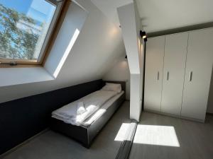 a small bedroom with a bed and a window at Apartament Rodzinny in Strzegom
