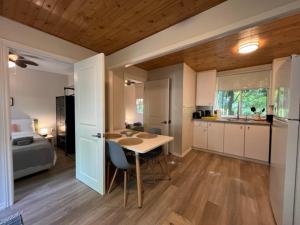 a kitchen with a table and a bed in a room at The Cozy Shore Cottage - Standard Single in Wasaga Beach