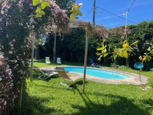 a swimming pool in a yard with two chairs at Suite Zen Grand Lit in Pierrelatte +31 photos