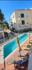 a swimming pool with two lounge chairs next to a building at Unique Two Bedroom Apartment -Lustica Centrale in Radovići