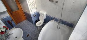 a bathroom with a toilet and a tub and a sink at 2 rooms Condo near Zoom Beach in Constanţa