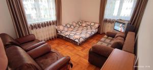 a living room with couches and a couch and a television at 2 rooms Condo near Zoom Beach in Constanţa
