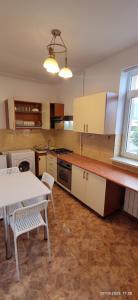 a kitchen with a table and a table and chairs at 2 rooms Condo near Zoom Beach in Constanţa