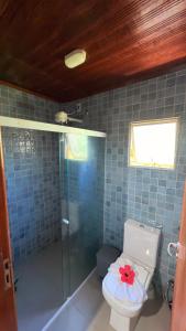 La salle de bains est pourvue de toilettes avec une fleur. dans l'établissement Flat Siriguela, à Fernando de Noronha 8 autres photos