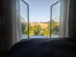 a bedroom with a large window with a view of a field at Nordic Designer Summerhouse - With a fantastic view in Vejby