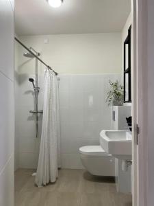 een witte badkamer met een toilet en een wastafel bij Casa Wechi in Willemstad