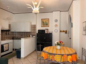 una cucina con tavolo e una piccola cucina con bancone di Il Rocchetto di Angelina a Guardia Piemontese Terme