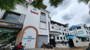潘达尔普尔Hotel Aishwarya的城市街道上的一座建筑,摩托车停在外面