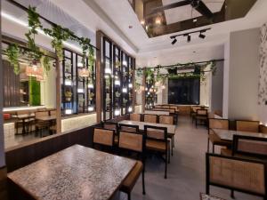 潘达尔普尔Hotel Aishwarya的有桌椅和窗户的餐厅