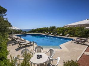 a swimming pool with chairs and a table at Stunning Oceanview Algarve Villa 9 Bedrooms Villa Quinta Marinha Amazing Location Overlooking Sea & Huge Pool Benagil in Lagoa