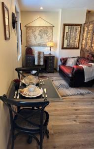 una sala de estar con una mesa y un sofá en STUDIO VOYAGE COLONIAL CLIMATISE chic, en Beauvais
