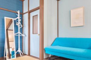sala de estar con sofá azul y espejo en 神樂谷, en Fujikawaguchiko
