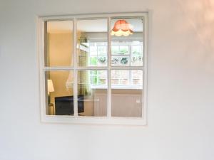a window in a white wall with a light at Cooper's Cottage in Louth
