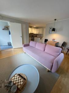 een woonkamer met een paarse bank en een tafel bij City Svolvær in Svolvær