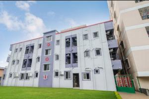a large white building with a green lawn in front of it at srh inn in Jāmb